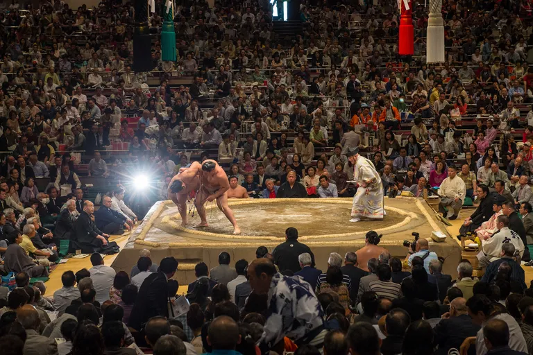 a group of men wrestling in a large crowd