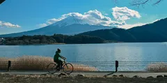 a person riding a bicycle next to a body of water